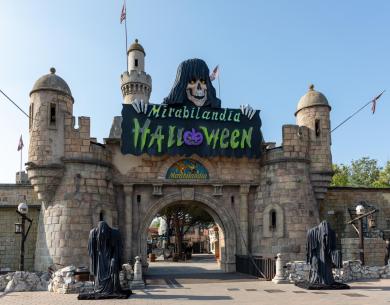 Entrée de Mirabilandia décorée pour Halloween avec château et figures fantomatiques.