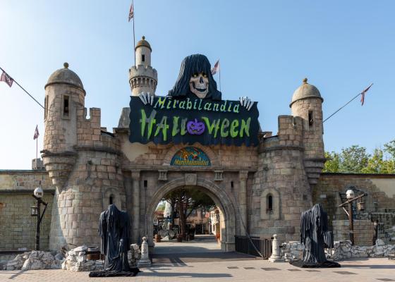 Entrée de Mirabilandia décorée pour Halloween avec château et figures fantomatiques.