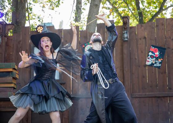 Deux acteurs en costumes d'Halloween jouent sur une scène extérieure.