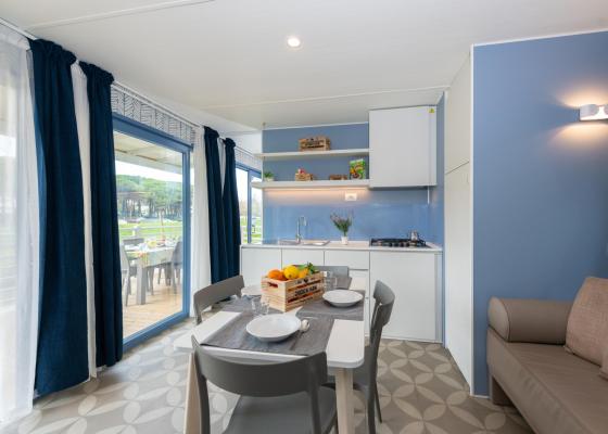 Bright, cozy kitchen with a view of greenery, table set.